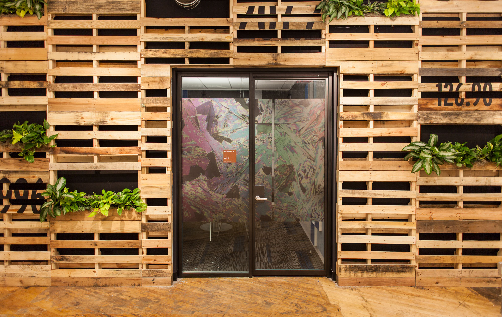 A conference room with vinyl graphics surrounded by a wall of wood pallets for an Elemental Environment