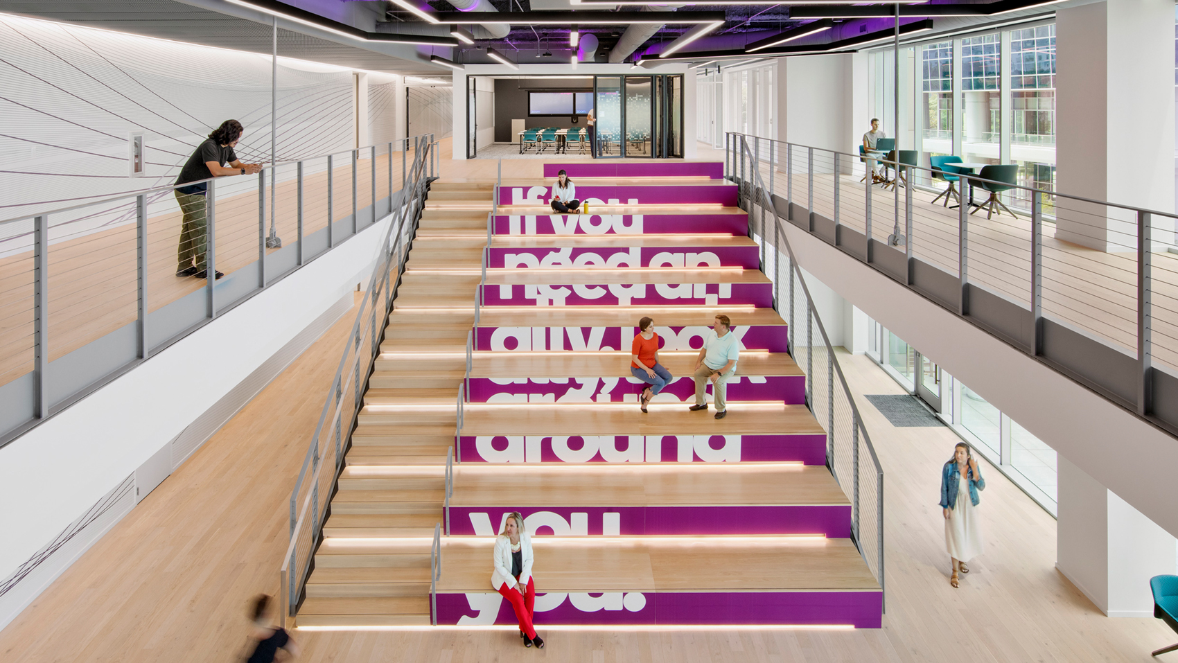 People sitting on large stairs. In between the stairs has text that reads "If you need an ally, look around you"