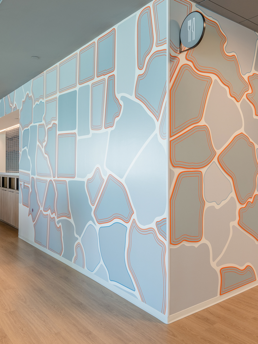 wall graphic with abstract gray and blue shapes with a bright orange outline