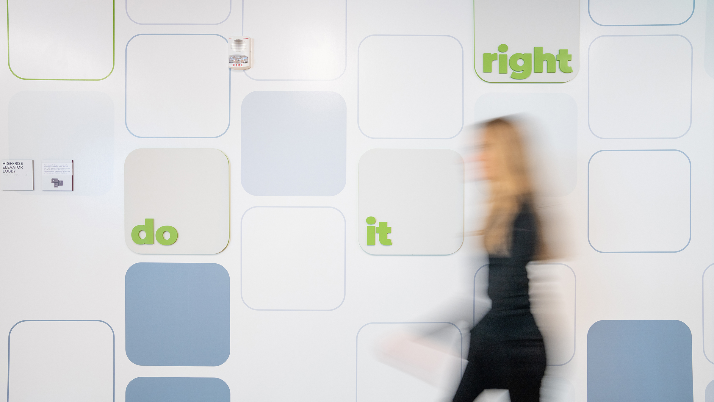Person walking past a wall graphic with dimensional rounded squares that say "do," "it," and "right"