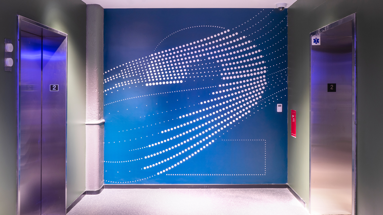 Wall graphic in elevator lobby. Graphic is blue with the number "2" large and made up of large dots